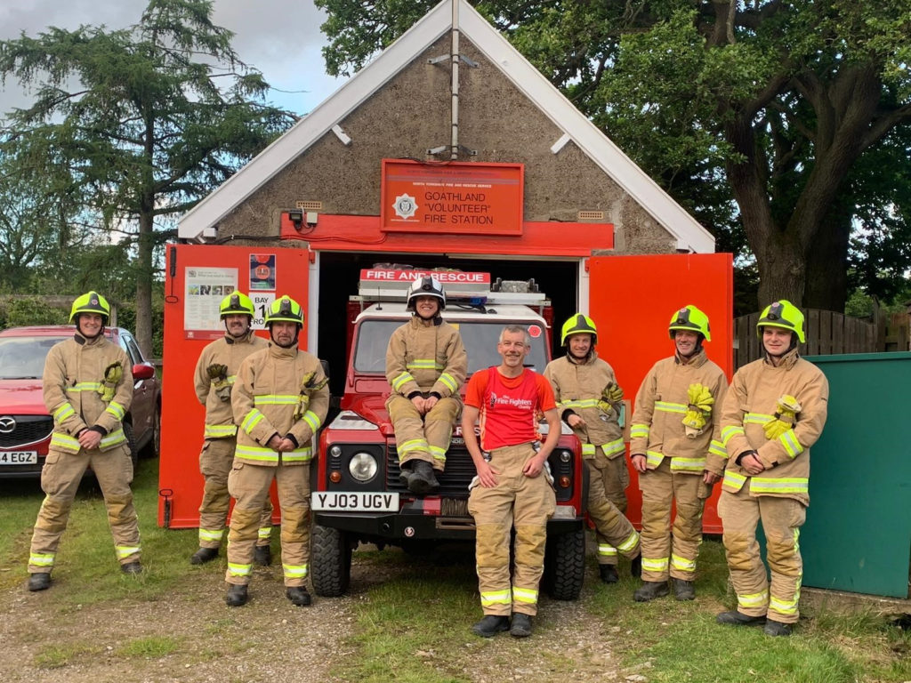 Rose Fearnley, QFSM, (seated on the Land Rover bonnet) with volunteers from the Goathland Fire Station following a charity event in 2019