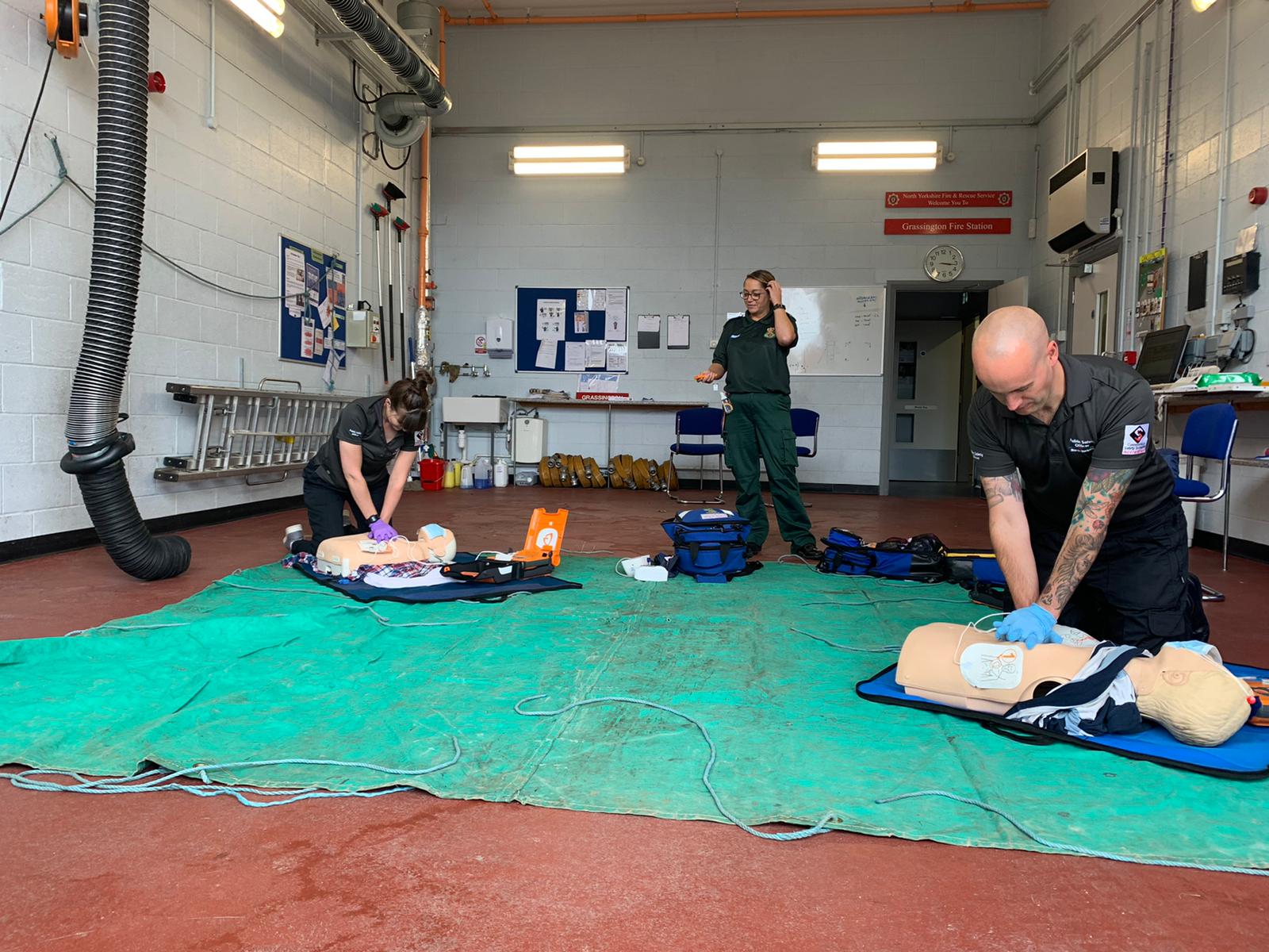 two public safety officers carrying out cpr on dummies with member of Yorkshire ambulance service